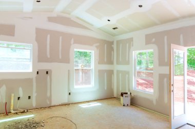 Plastering drywall new home industry on finishing putty in the room walls plasterboards with room under construction clipart