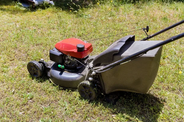 Lawn mower cutting in the grass on sunny spring day — Stock Photo, Image