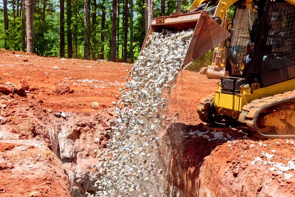 Kazıcı endüstriyel inşaat alanına bir taş yüklüyor.