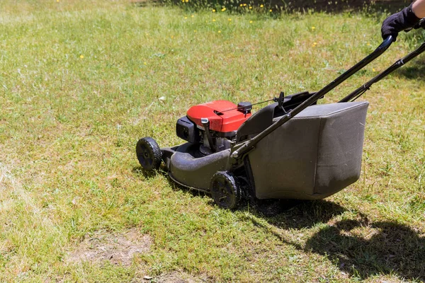 Wanita memotong rumput menggunakan mesin pemotong rumput bertenaga bensin. — Stok Foto