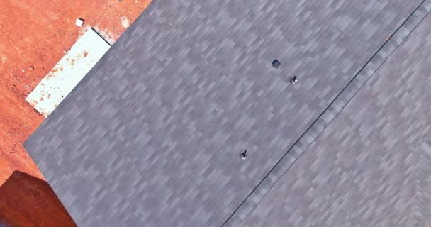 공중에서 보면, 모퉁이 지붕의 널빤지에 새로 지을 집을 위해 방수제를 하고 있는 아스팔트 널빤지가 보인다 — 비디오