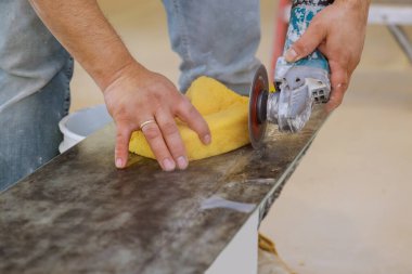 İşçi elleri seramik fayansları dairesel testereyle kesiyor.