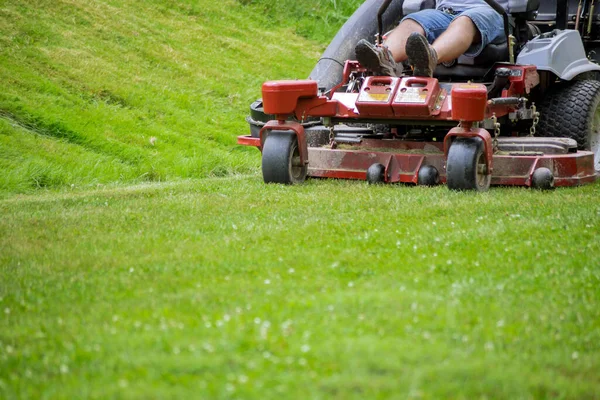 Man klipper gräsmatta med hjälp av bensindrivna självgående gräsklippare — Stockfoto