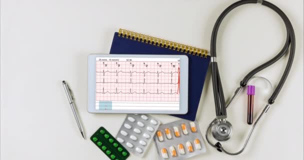 Kardiograph ekg Elektrokardiogramm Herz zeigt in Tablette mit medizinischen Dokumenten auf dem Schreibtisch des Arztes — Stockvideo