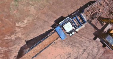 Bir endüstriyel odun öğütücü iş kökleri öğütme makinesinde yonga haline geliyor.