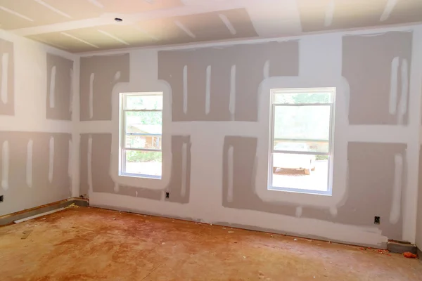 Laid plastering gypsum on the walls and ceiling of a newly built house to drywall seams