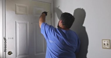 Tadilat odasının ön kapısı beyaz boyayla boyanmış.