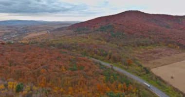 Dağlık kırsal arazinin havadan tepedeki manzarası köyün yakınındaki ormanlarla güzel bir manzara.