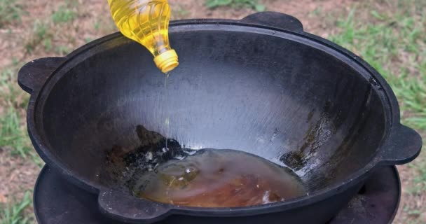 Hand Pours Sunflower Oil Empty Cast Iron Cauldron — Stock Video