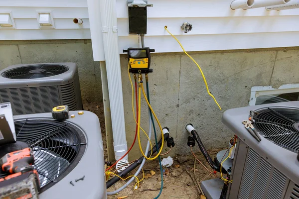 Technician repairing the air conditioning unit outdoors with multimeter meter liquid cooling