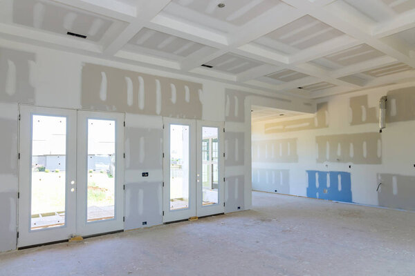 A newly constructed house is using the finishing putty applied to prepare painted to its walls