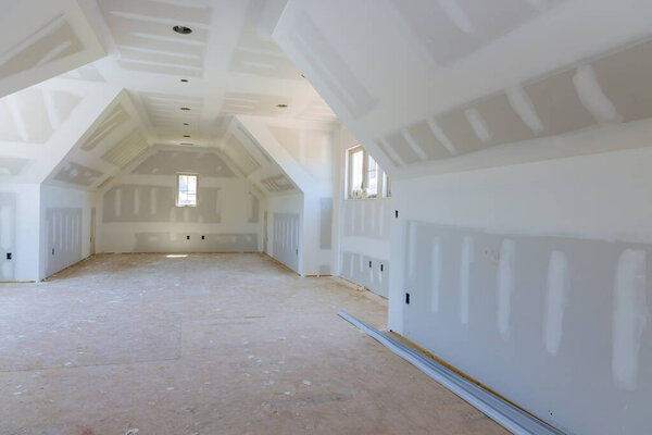 As the walls of an empty apartment are being painted, finishing putty is being applied