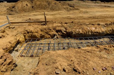 İnşaat alanında güçlendirilmiş beton ve çelik çubuklar kullanarak bir yapı inşa ediliyor.