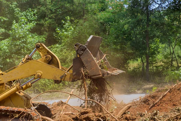Land cleared from roots for housing development subdivision using tractors skid steers