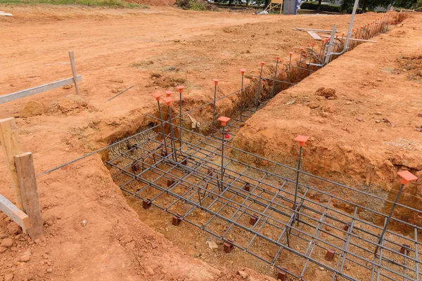 Putting steel in a trench for a house foundation on construction site