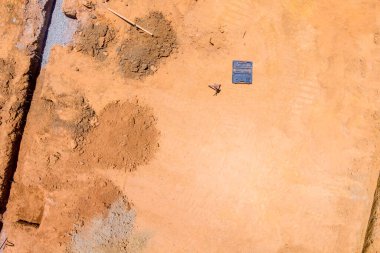 Beton bir temelin altında hendek kazılmış bir inşaat alanının havadan görüntüsü.