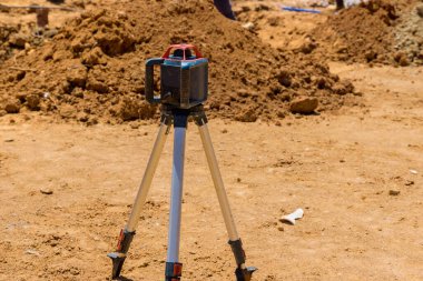 İnşaat alanındaki müteahhit inşaat malzemelerinin lazer seviyesini ölçmek için yol inşaatı sırasında kullanılıyor.