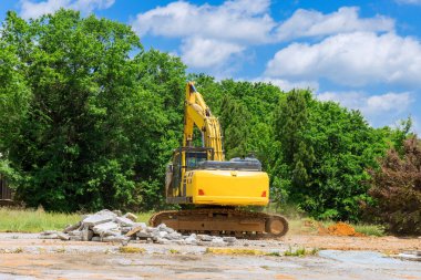 İnşaat alanındaki kazıcı beton döşemeler için eski beton eziciyi keser ve parçalar.