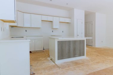 Beyaz mutfak ahşap dolapları ev dekorasyonu manzaralı mobilyaların içine yerleştirilmiş.