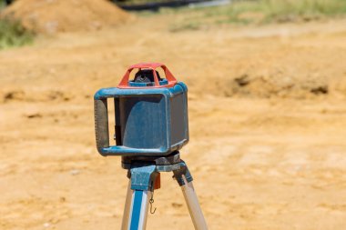İnşaat müteahhiti seviye çubuk lazer inşaat ölçüm ekipmanı kullanıyor.