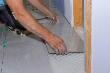 Tile installation on adhesive surfaces during home construction with renovation bathroom