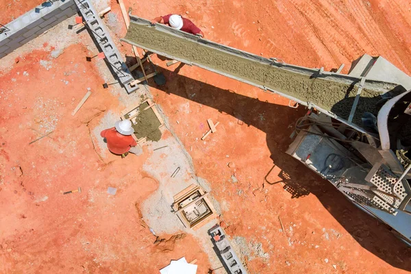 The pouring of concrete columns on a construction site, an aerial view from a concrete mix car