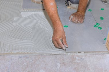 Ev inşaatı ile seramik zemin fayansları yenileme banyosunda yapıştırıcı bir yüzeye yerleştiriliyor.