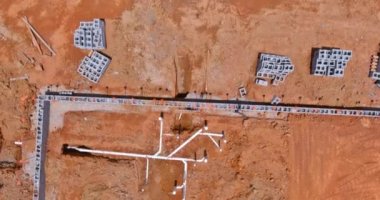 Yeni bir konut inşaatının temelinin altına kanalizasyon ve su boruları döşeniyor.