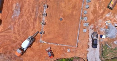 Construction workers pouring concrete columns at a building site an aerial view