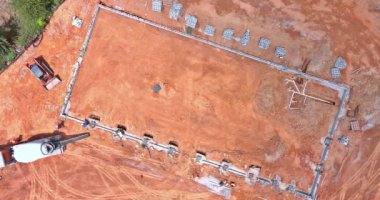 Süreç beton karıştırıcı kamyon kullanarak yeni bir ev inşa etmek için beton sütunlar döküyordu..