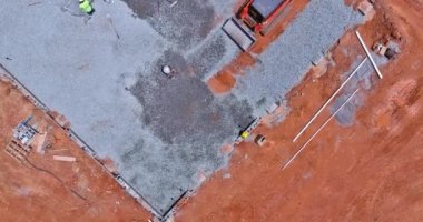 Excavator bucket working in leveling gravel the building foundation on a construction site