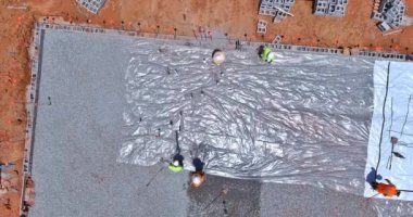 Installation of barrier plastic before pouring concrete foundation construction the building
