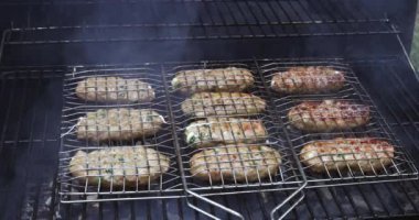 Sıcak barbekü ızgarasında, karışık Amerikan barbeküsü hamburgerle kızartılır.