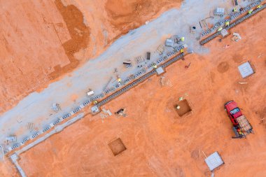 İnşaat alanındaki montaj işleminin bir parçası olarak bir duvarcı tarafından havalanan beton blok bir duvar monte ediliyor.