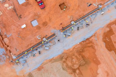 Duvarcı bir adam havalandırmalı beton bloklardan bir duvar örerken duvarlara doğru yatıyordu.