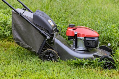 This is a garden care work tool working lawn mower on green lawn with grass being cutting in sunny day