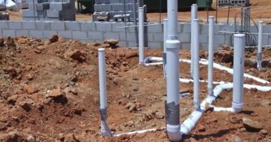 Yeni bir konut inşaatının temelinde, kanalizasyon boruları ve su boruları toprağa gömülüdür.