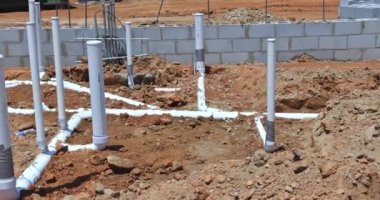 Laying PVC plastic pipes sewer sewage pipes system in ground during plumbing construction site under the foundation