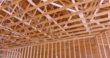The roof trusses of a new residential building under construction are seen on the roof post beam framework