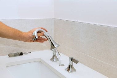 Bir muslukçu banyo için bir musluk kurar ve onu iş yerine yerleştirir.