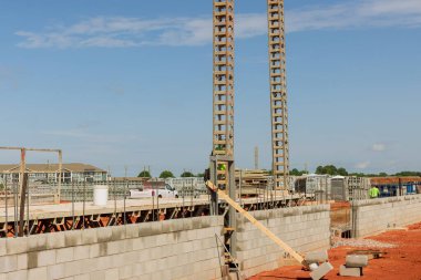 İnşaat alanındaki beton bloklardan oluşan duvarı inşa etmek için yığılmış iskeleye hazırlık