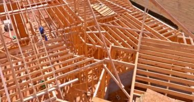 From an aerial top view, a new build is seen with wooden timber trusses frame beam framework