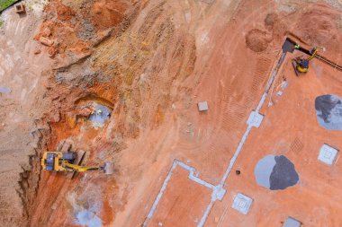 Kanalizasyon bağlantısı tamamlanabilsin diye yeraltı kanalizasyon boruları yerleştirilirken kazıcı tarafından bir çukur kazılır.