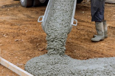 Bir garaj yolu inşa edilirken, yeni evin tepesine ıslak beton dökülür.