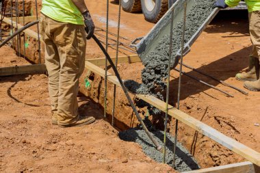 Building house through the pouring of concrete trenches on top a solid foundation in construction zone