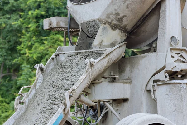Concrete mixer truck is being delivered fresh concrete to foundation on preparation to pour the concrete into foundation in construction site
