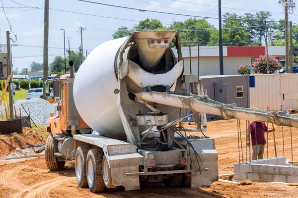 To prepare to pour concrete into the foundation, a concrete mixer truck brings fresh concrete to site for delivery in construction area