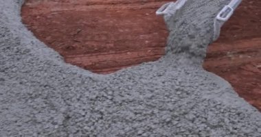 Working on pouring cement into new concrete driveway for a residential house in construction site