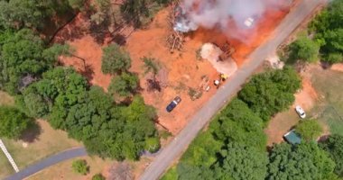 Clearing land from roots for a subdivision using tractors skid steers near forest with uprooted and burning the forest an environmental problem