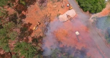 New plot land development for new construction using heavy bulldozing equipment, uprooted and burning the woods an environmental problem